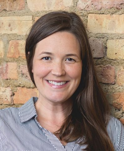 Woman wearing a striped shirt against a brick background