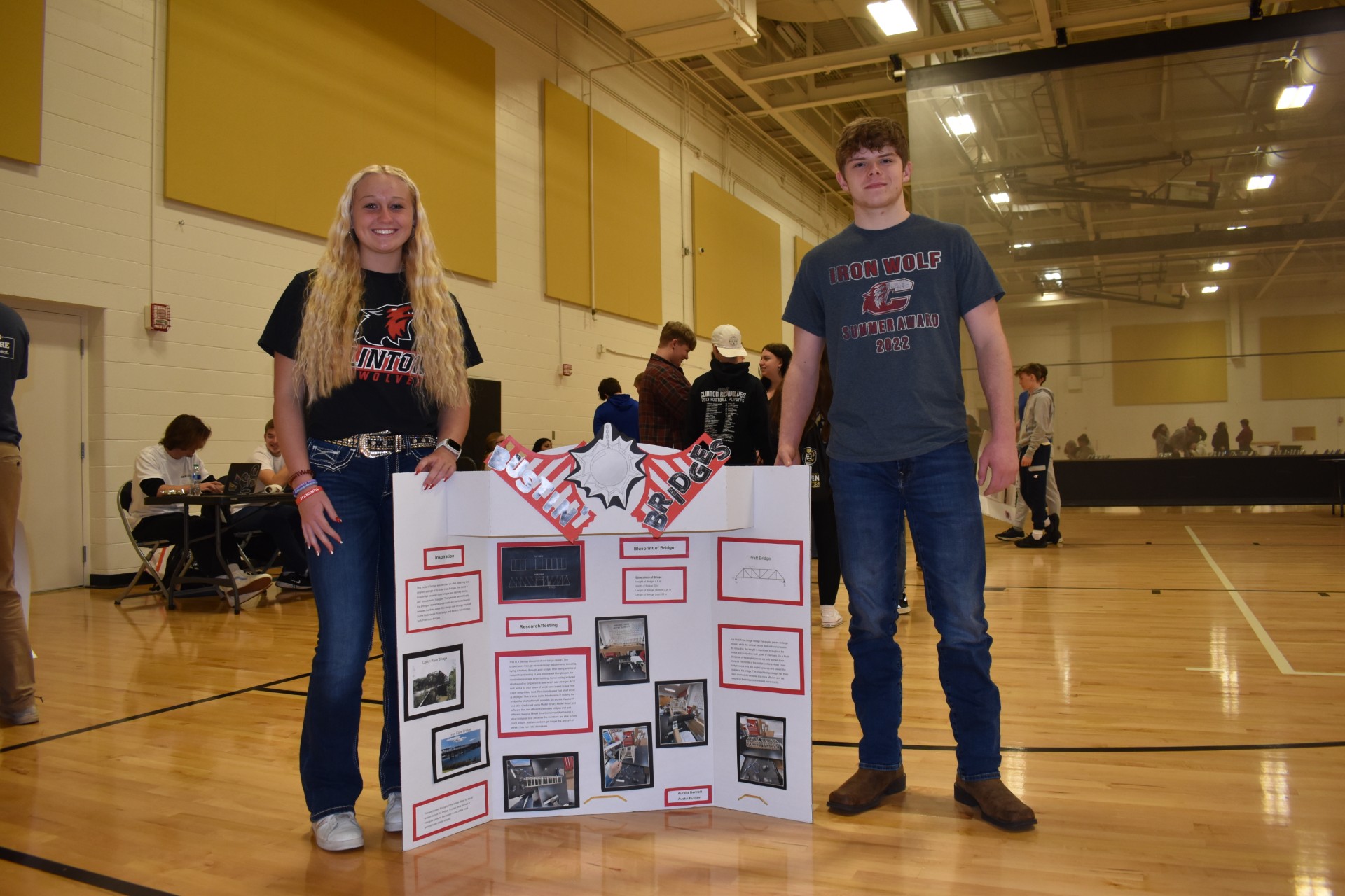 two contestants with  poster board about their bridge